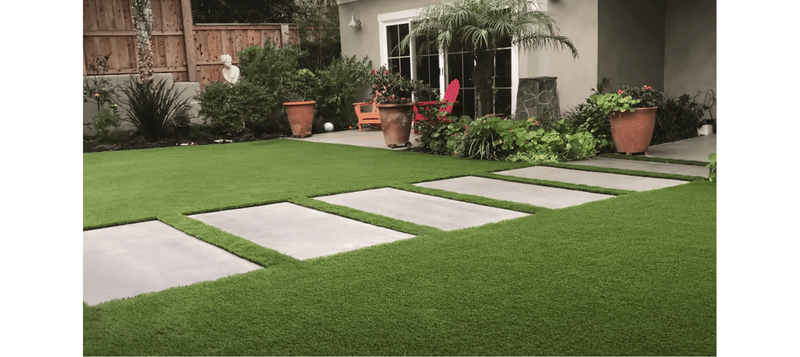 backyard with artificial turf and large concrete paver pathway